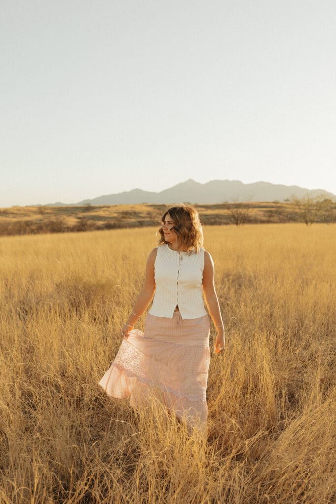 Photograph-of-high-school-senior-girl-walking-in-sonoita-arizona-field